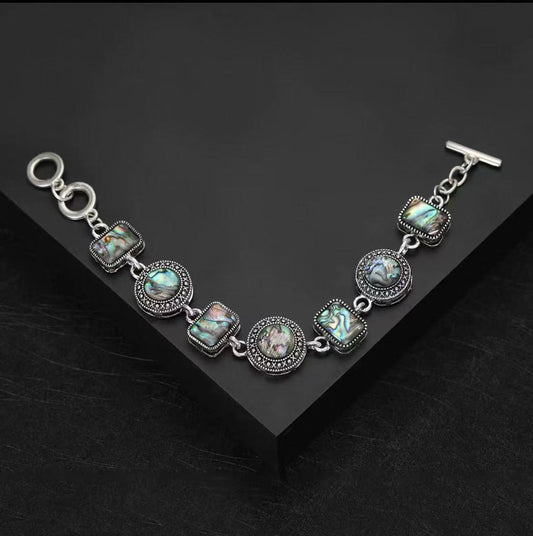 Retro-style abalone shell bracelet with creative, adjustable three-ring clasp.